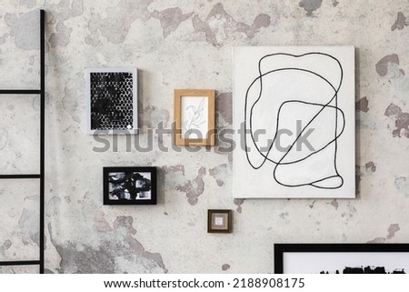 Loft style of modern apartment with composition of wall art gallery. Mock up poster frames. Minimalist home decor. Template. Grunge concrete wall.