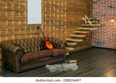 Loft style room interior with leather sofa and wooden wall. Electric guitar and book in room - Powered by Shutterstock