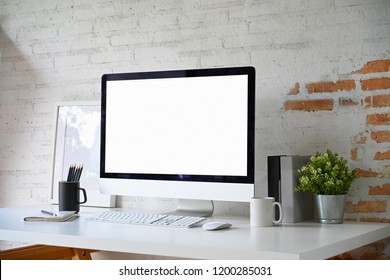 Loft workplace with mockup blank screen desktop computer and home office accessories - Shutterstock ID 1200285031