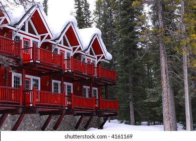 Log Building Of A Mountain Lodge In Winter At Ski Resort With Pine Trees