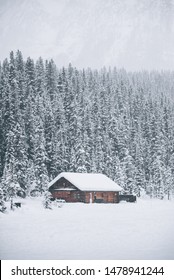 Log Cabin By Frozen Lake In Winter 