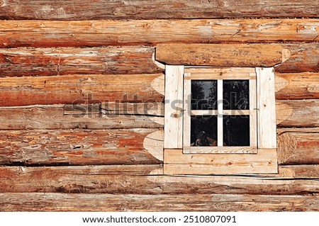 Log cabin and a small window on the wall, wooden construction background, a corner of a log cabin made of logs. House made of logs in traditional Russian style