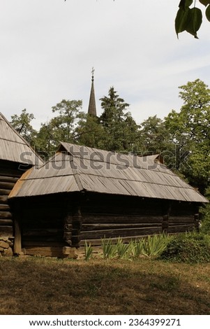 A log cabin with a tall spire in the background with Air Force Armament Museum in the background
