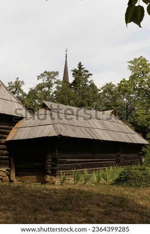 A log cabin with a tall spire in the background with Air Force Armament Museum in the background