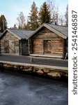 Log cabins on the pier at icy water. Cold winter scenery.