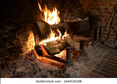 Log Fire: Logs Ablaze On Fire Dogs In The Hearth Of Red Brick Fireplace