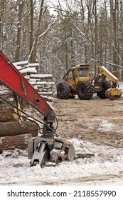 Log or Logging Skidder and Knuckleboom loader with Freshly Harvested and piled timber logs
