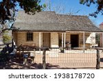 A log and rock cabin with porch at Lyndon B. Johnson State Park and Historic Site and the Sauer-Beckmann Farmstead, a living history farm in Stonewall, Texas. The farmhouse was built in the mid-1800s.