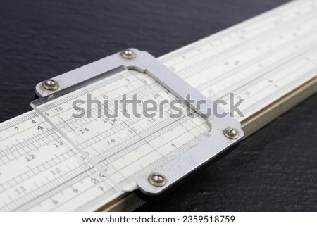 Logarithmic ruler on black background. Stationery for engineers and students