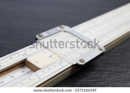 Logarithmic ruler on black background. Stationery for engineers and students