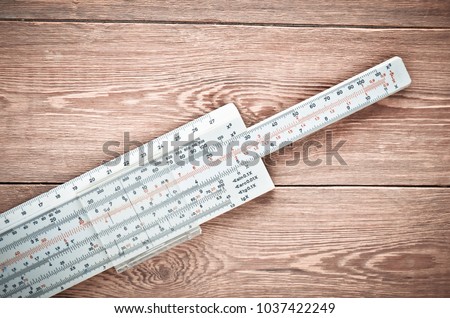 Logarithmic ruler on a wooden table. Stationery for engineers and students.

