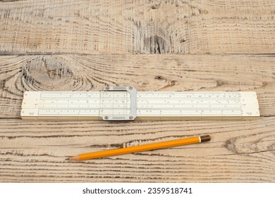 Logarithmic ruler, pencil on a wooden table. Stationery for engineers and students