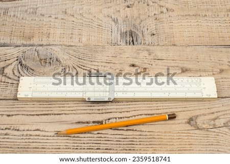 Logarithmic ruler, pencil on a wooden table. Stationery for engineers and students