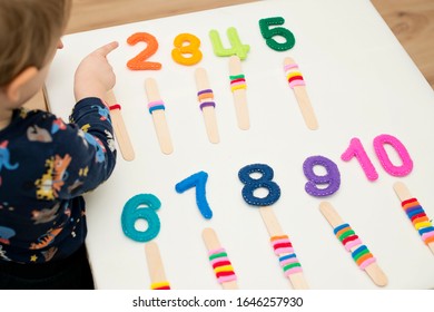 logic and counting game for early education. Stuffed felt numbers and Popsicle Sticks with hair tie gum on it.   Each popsicle have dedicated number of ring. 