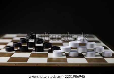 logical and educational checkers game for family and friends. on a brown board, white and black checkers are arranged in a pyramid. for banners labels booklet splash screens