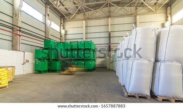 logistic, storage, shipment, industry and\
manufacturing concept timelapse  - forklift loader at work moves\
green container at\
warehouse