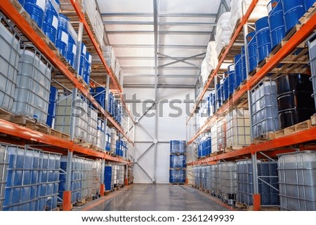 Logistic warehouse. Storehouse with barrels on racks. Multi-tier storage shelves in hangar. Warehouse without people. Place to store barrels and cisterns. Logistic warehouse in industrial building.