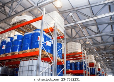 Logistic warehouse. Storehouse with shelving. Storage racks. Warehouse interior with barrels. Place to storage petrolium. Storehouse in manufactory building. Petrolium barrels are stored in hangar