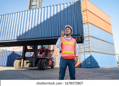 Logistics engineer control at the port, loading containers for trucks  export and importing logistic concept