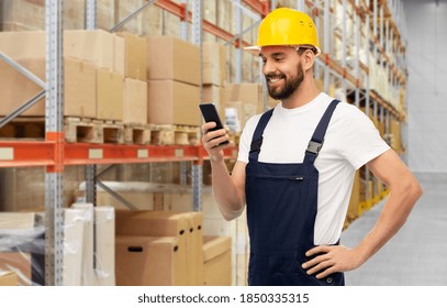 logistics, profession and job concept - happy smiling male worker or loader in yellow helmet and overall with smartphone over warehouse background - Powered by Shutterstock