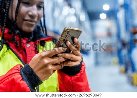 Logistics professional checking inventory with a mobile phone, optimizing cold chain operations and managing supply in a modern frozen warehouse environment