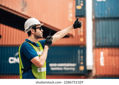 Logistics, shipping and construction worker man using walkie talkie in shipyard. Transportation engineer on smartphone in delivery, freight and international distribution business in container yard - Powered by Shutterstock