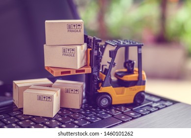 Logistics, supply chain and delivery service concept : Fork-lift truck moves a pallet with box carton. Boxes on a laptop computer, depicts wide spread of products around globe in ecommerce booming era - Shutterstock ID 1460101262