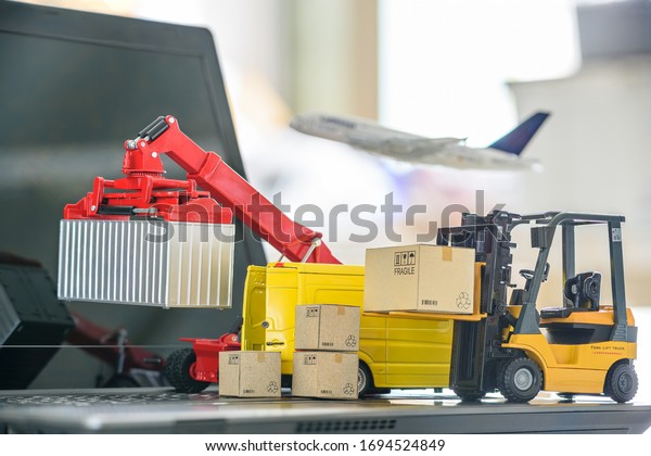 Logistics, supply chain and delivery service concept\
: Fork-lift truck moves a box or container. Van on a computer,\
depict booming of customers demand on goods / products in ecommerce\
disruptive era