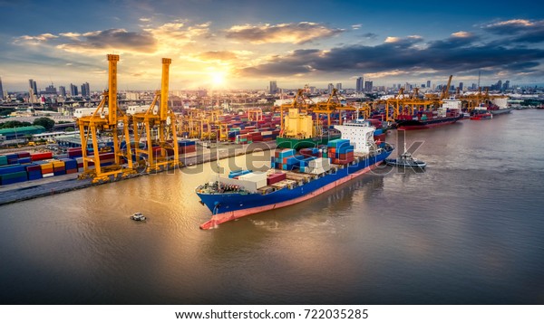 Logistics and transportation of Container Cargo\
ship and Cargo plane with working crane bridge in shipyard at\
sunrise, logistic import export and transport industry background,\
Aerial view from\
drone