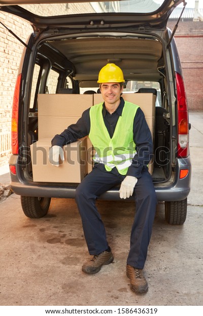 Logistics worker of a freight forwarder with parcel\
delivery in a pickup\
truck
