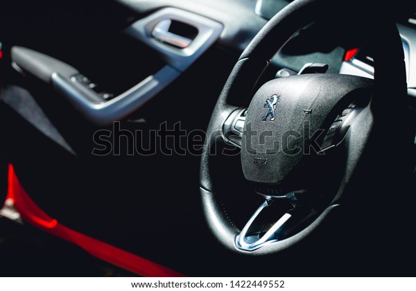 \
Logo of Peugeot. Photo of the interior of a car\
peugeot 208 automatic model 2014. Highlight the vehicle steering\
wheel with a company logo. Brasilia, Federal District - Brazil.\
June, 12, 2019. 