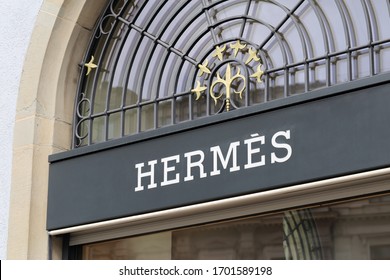 Logo Sign Of Hermes On A Wall Of An Old Building Located In Downtown Bern, Switzerland, March 2020. The Logo Is Lit Up. Hermes Is A Brand That Offers Luxury Goods And Is Famous Of Designer Handbags.