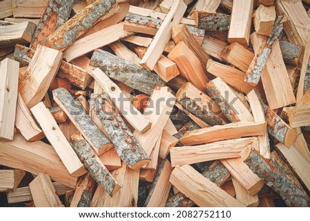 Logs, natural wood texture background. Pile of chopped firewood tree logs at lumber mill. Preparation for winter time. Fireplace or stove material. Timber industry concept. Close up, selective focus