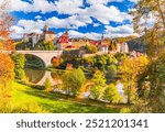 Loket, Czech Republic. Picturesque autumn landscape of Bohemia features vibrant orange and golden foliage, a medieval castle atop a hill and winding river.