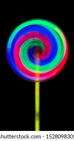 Lollipop toys  growt in the dark Consisting of green, red, blue and yellow handles spin, black background