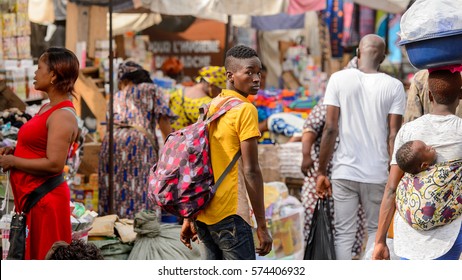 LOME, TOGO - Jan 9, 2017: Unidentified Togolese man carries backpack from behind at the Lome central market. Togo people suffer of poverty due to the bad economy