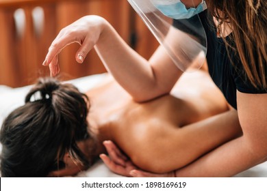 Lomilomi Practitioner Wearing A Protective Mask, Giving Back Massage With An Elbow At A Wellness Center