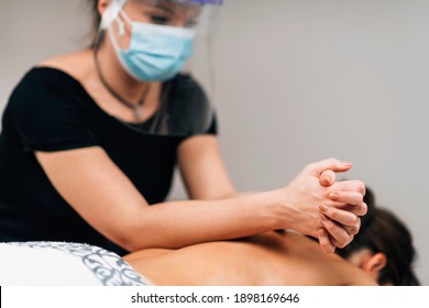 Lomilomi Practitioner Wearing A Protective Mask, Giving Back Massage With An Elbow At A Wellness Center