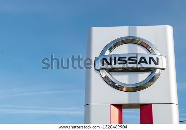 LOMME,FRANCE-February 17,2019: Nissan brand logo on\
a blue sky background.Nissan is a Japanese international car\
manufacturer, the company was created in\
1911.