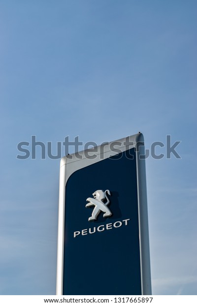 \
Lomme,FRANCE-February 17,2019:View of a peugeot brand\
logo on a blue sky background.Peugeot is a French company producing\
cars, motorcycles and scooters. The company was founded in 1810.\
