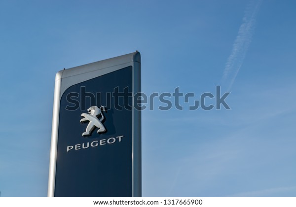 \
Lomme,FRANCE-February 17,2019:View of a peugeot brand\
logo on a blue sky background.Peugeot is a French company producing\
cars, motorcycles and scooters. The company was founded in 1810.\
