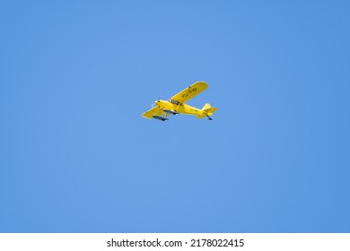 Lommis, Switzerland, May 11, 2022 Piper PA18-150 Super Cub Propeller Plane In The Blue Sky