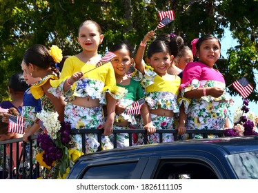 Lompoc, California, USA - June 27, 2015: Young Hispanic Girls Wave United States Flags During A Small Town Festival Parade.