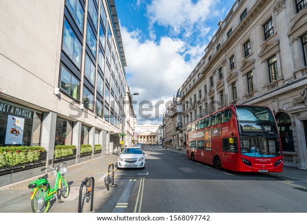 LONDON - 2019: Red bus, car and\
bicycle on a London street. Without people. London\
transport.