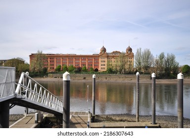 LONDON - APRIL 18 2022. The old Harrods Furniture Depository overlooking the River Thames was built for storing large retail products, now converted to apartments located at Barnes, west London.