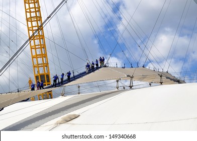 LONDON - AUGUST 3. Climbers on the O2 Arena entertainment dome 53 metre (174 feet) high 'Roof Walk', a fabric walkway suspended from masts on August 3, 2013, on the Greenwich Peninsula, London, UK.