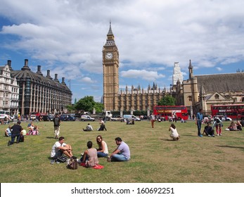 LONDON - AUGUST 5, 2013:  London's Busy Traffic Moves Around The Parliament Building As Tourists Rest In A Quiet Park Across The Street, In London On August 5, 2013.