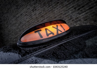 London Black Taxi Cab Waits In A Backstreet With It Orange Light On To Be Hailed.