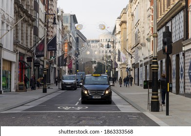 A London Black Taxi waiting at traffic lights on New Bond Street. London - 28th November 2020