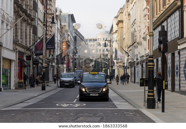 A London Black Taxi waiting\
at traffic lights on New Bond Street. London - 28th November\
2020